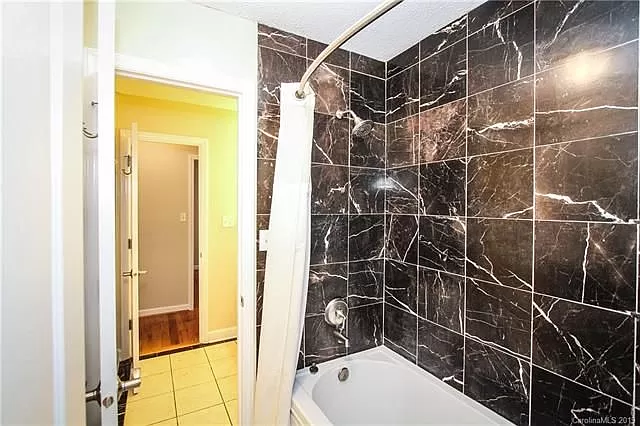 Bathroom picture before - white bath with black tiled walls