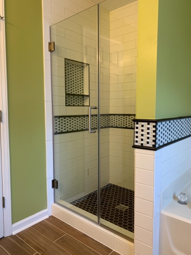 Bathroom with green walls, white tiling and black hexagonal tiles for accent